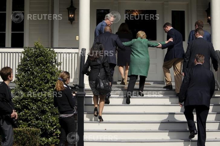 Hillary Clinton appears unable to walk up a few steps on her own, requiring assistance from two apparent Secret Service agents. Image Credit: Reuters.