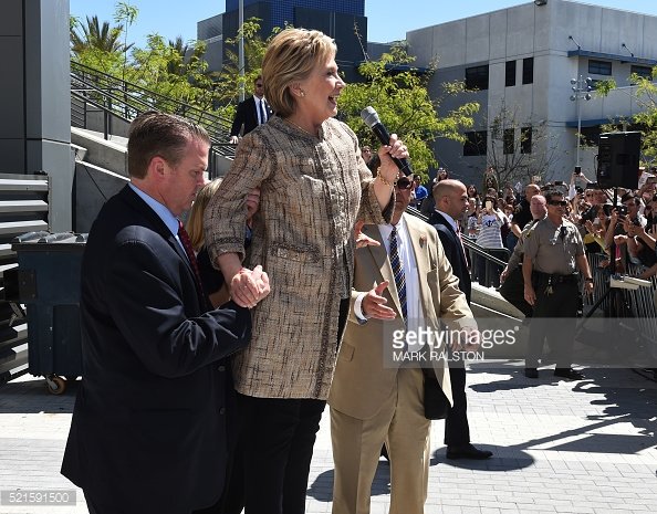 Hillary Clinton appears unable to stand on her own, requiring assistance from apparent Secret Service agent. Image Credit: Mark Ralston/ Getty Images.