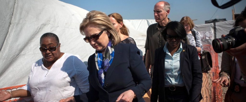 Secretary Hillary Clinton, her advisor/ lawyer, Cheryl Mills (right in light blue), and others arrive in Haiti. Clinton was in charge of distributing U.S. aid to the country (Image Credit: ABC News).
